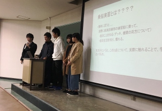 写真1 資料を提示して説明する2年生